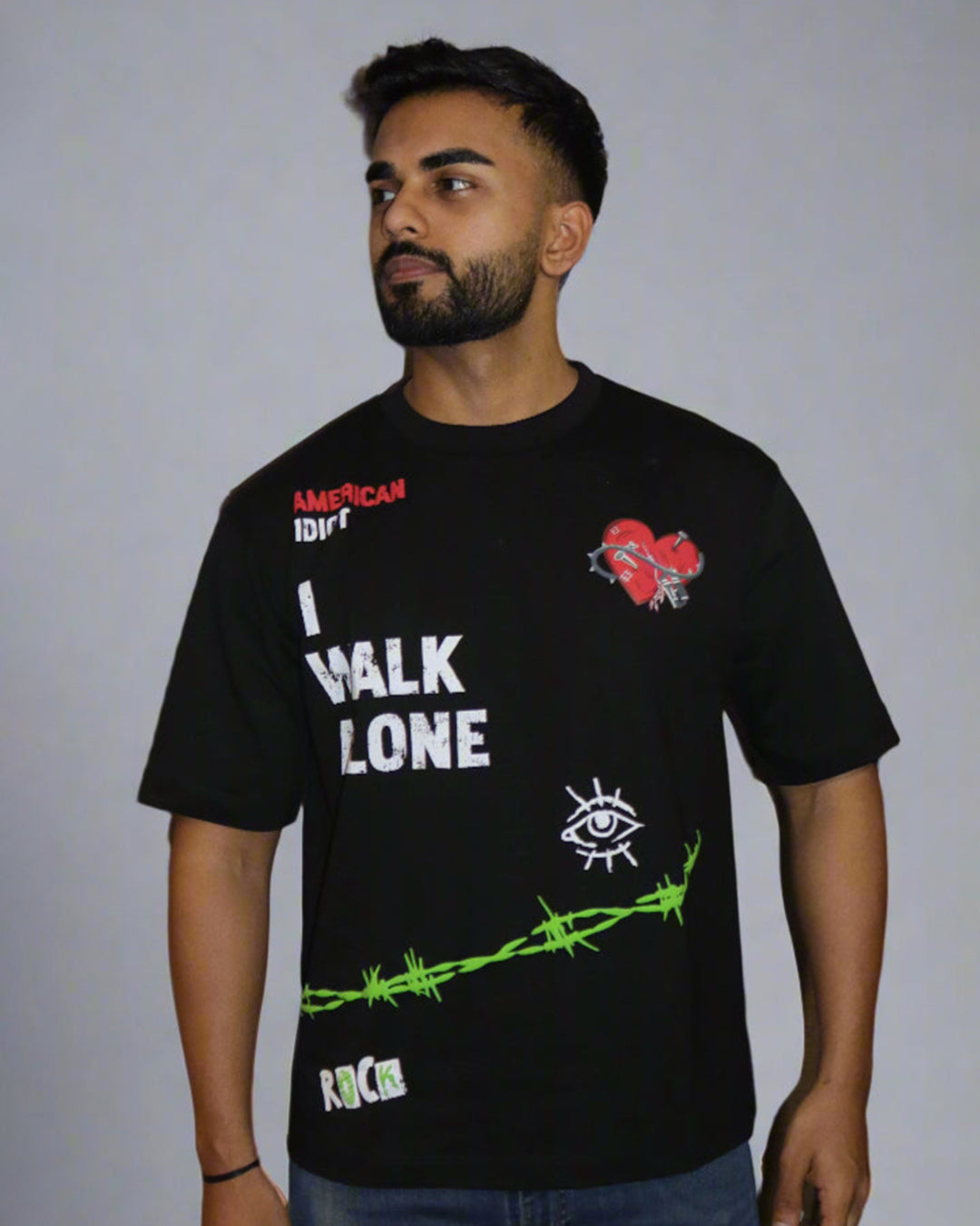 man wearing a black tshirt with "i walk alone" and "American Idiot" written on the front.