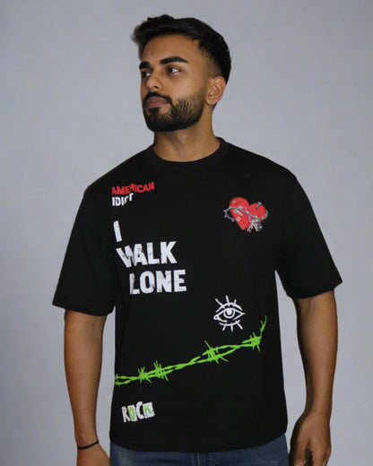 man wearing a black tshirt with "i walk alone" and "American Idiot" written on the front.