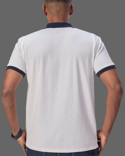 Man wearing a white polo shirt with navy accents on a plain background