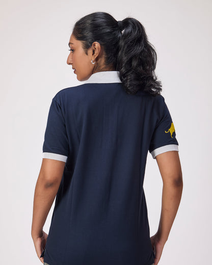Person wearing a navy blue polo shirt with a logo on the sleeve against a white background