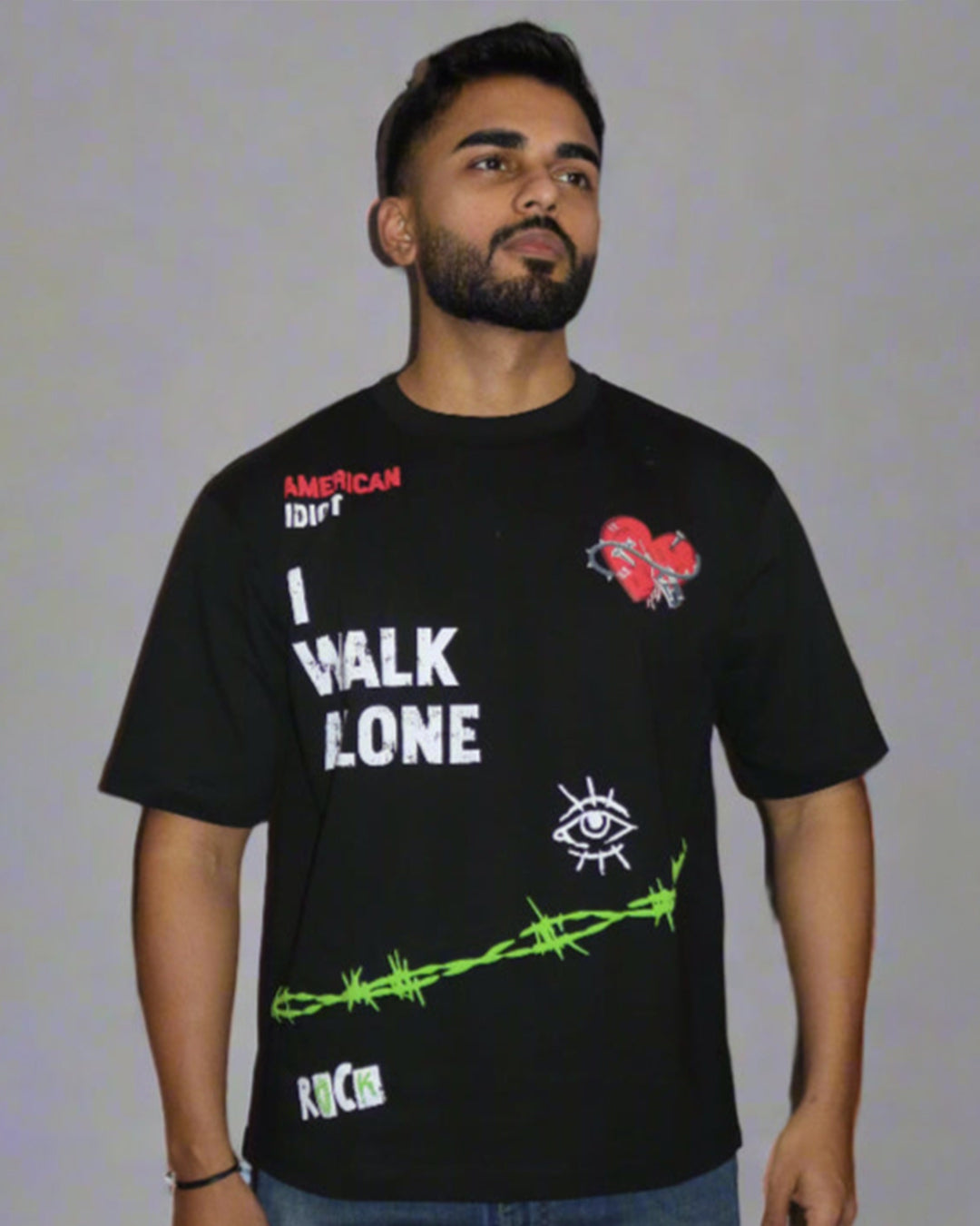 man wearing a black tshirt with "i walk alone" and "American Idiot" written on the front.