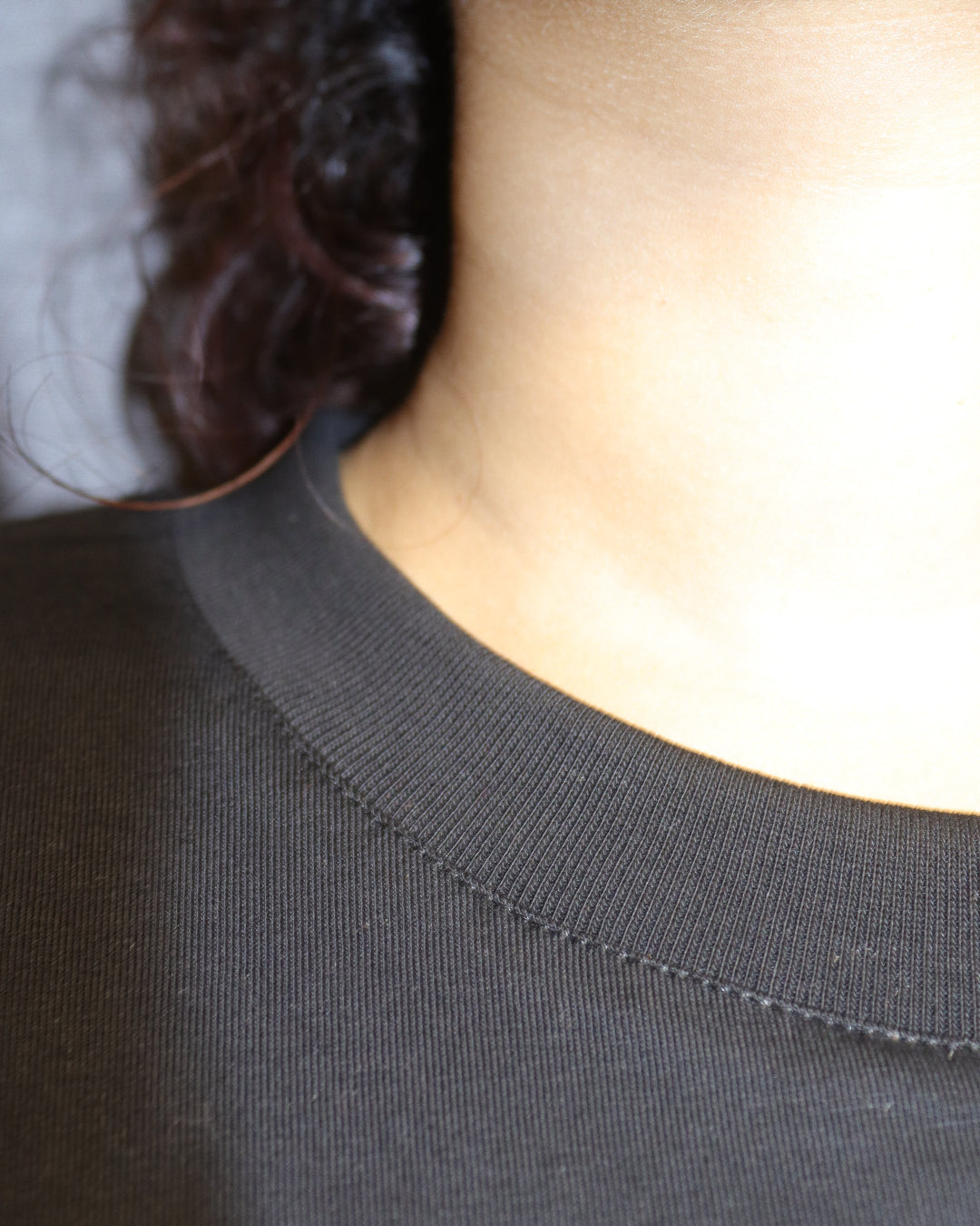 man standing showing his tshirt neck and Stitches