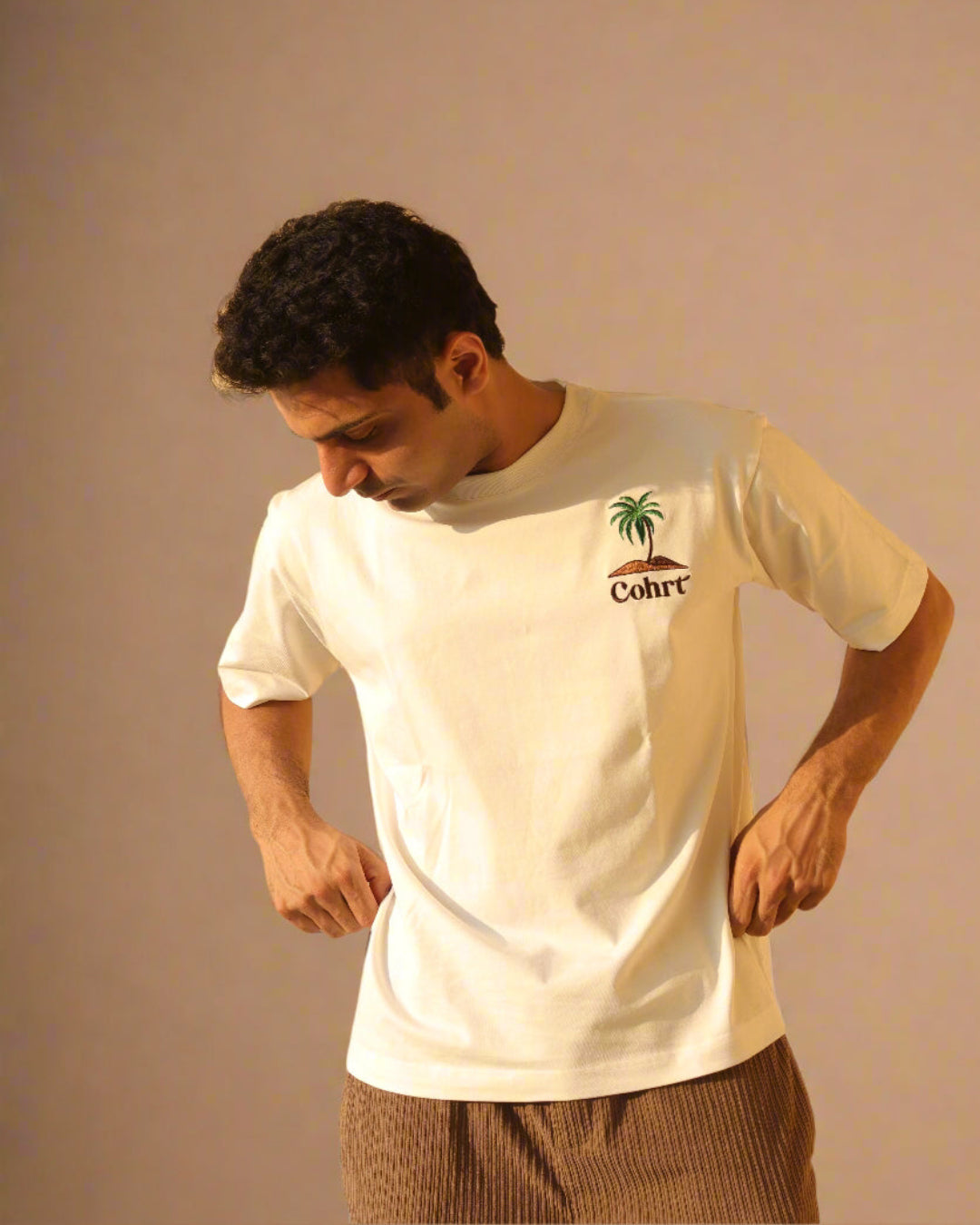Man standing Wearing white t-shirt and Palm tree on the pocket side 