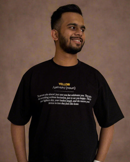 man standing wearing black tshirt, yellow and its meaning written in the front